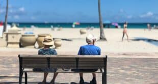 Zwei Rentner auf einer Bank vor dem Strand